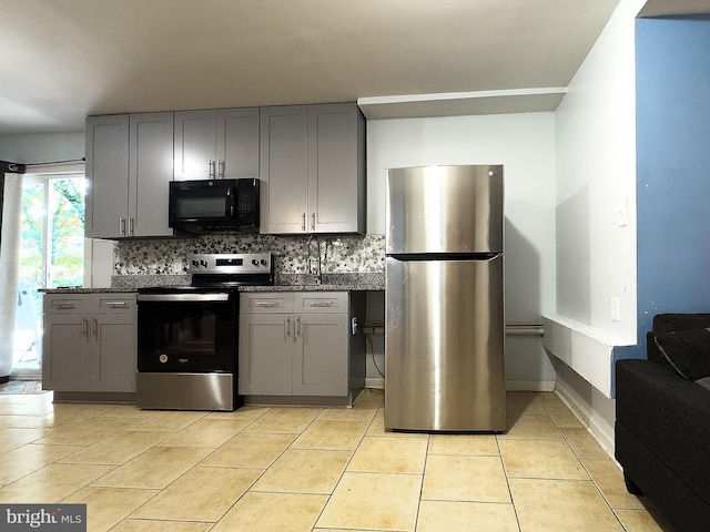6802 Temple Hill Rd, Temple Hills, MD 20748 - kitchen with appliances with stainless steel finishes, gray cabinetry, backsplash, and light tile patterned flooring