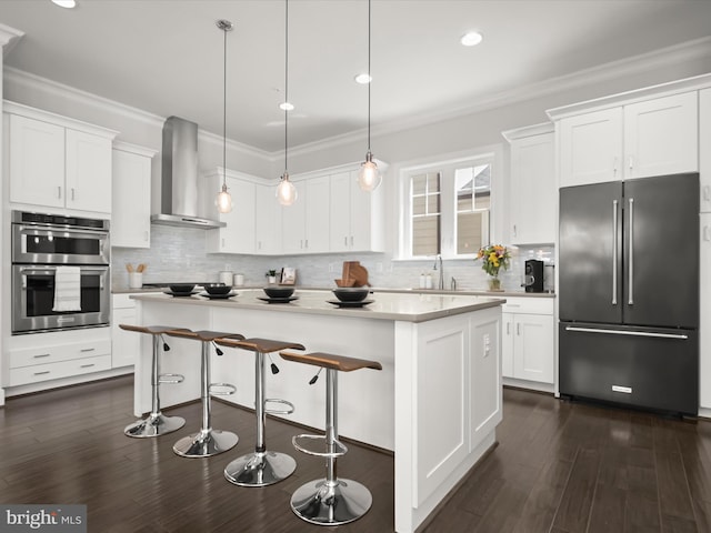 11412 Dairy St, Fulton, MD 20759 - kitchen with high end fridge, wall chimney range hood, stainless steel double oven, white cabinets, and crown molding