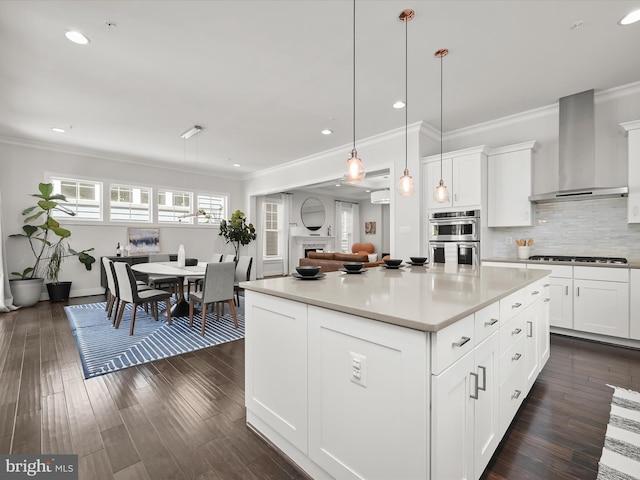 11412 Dairy St, Fulton, MD 20759 - kitchen featuring wall chimney range hood, stainless steel double oven, gas stovetop, ornamental molding, and a center island