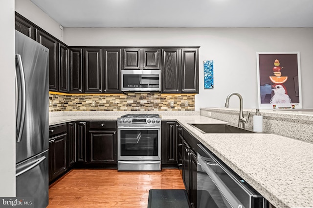 605 N Atlantic Ave Unit 104, Collingswood, NJ 08108 - kitchen featuring stainless steel appliances, dark cabinetry, light wood-type flooring, and tasteful backsplash