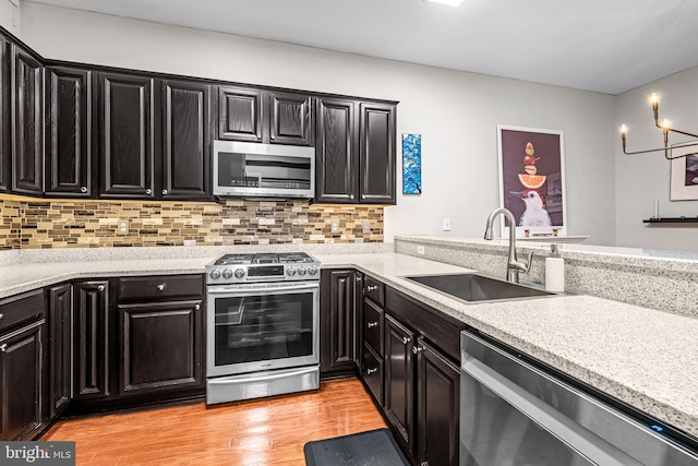 605 N Atlantic Ave Unit 104, Collingswood, NJ 08108 - kitchen with stainless steel appliances, dark cabinets, light countertops, light wood-type flooring, and decorative backsplash