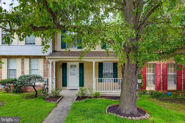 8125 Greenspring Vly, Owings Mills, MD 21117 - view of front of house featuring covered porch, a front lawn, and brick siding