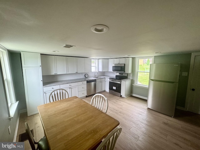 6054 Baltimore Pike, Littlestown, PA 17340 - kitchen featuring appliances with stainless steel finishes, white cabinetry, light countertops, and light wood-type flooring