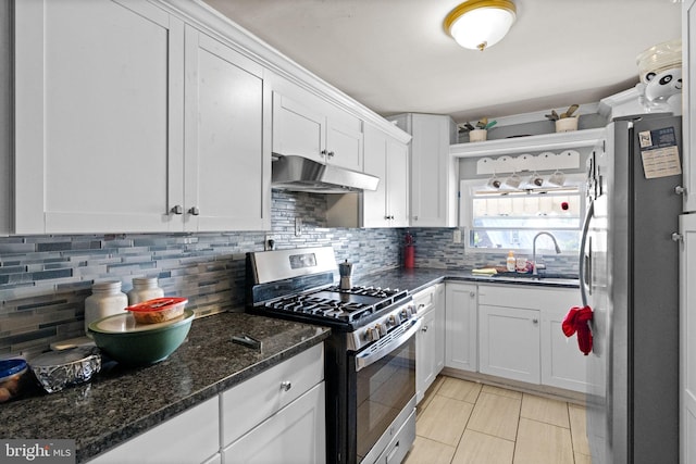 330 N 13th St, Reading, PA 19604 - kitchen with stainless steel appliances, under cabinet range hood, white cabinetry, and decorative backsplash