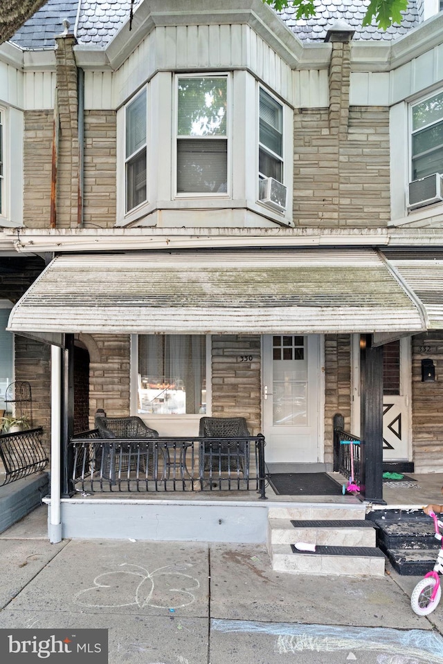 330 N 13th St, Reading, PA 19604 - view of front of home with a porch, cooling unit, a high end roof, and stone siding