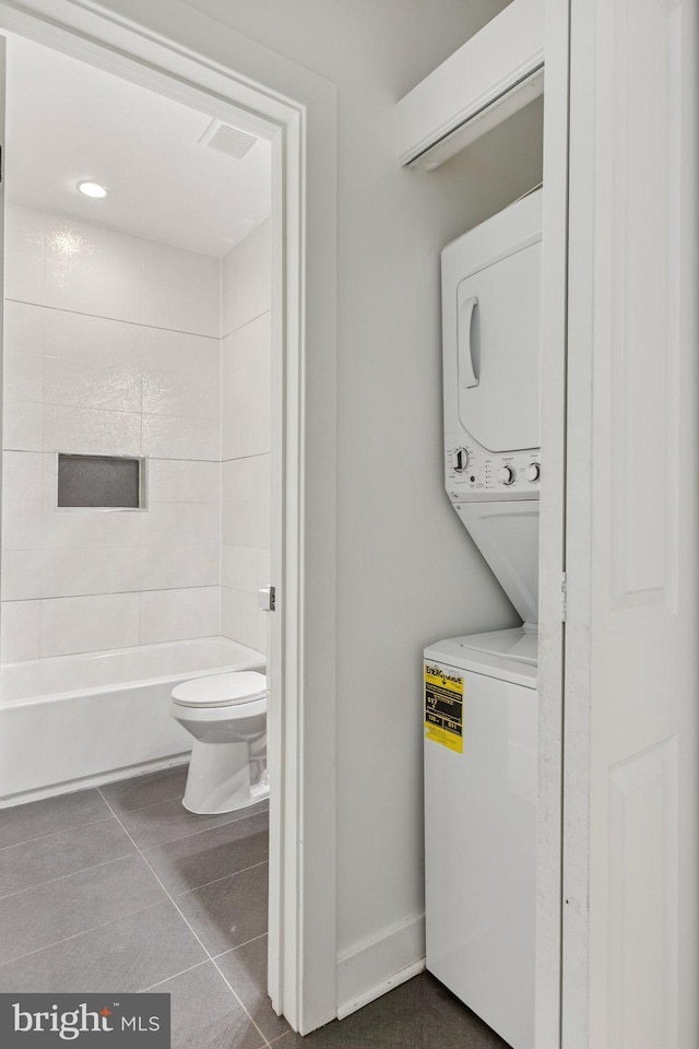 429 20th St NE Unit 1, Washington, DC 20002 - laundry room with stacked washer / dryer and dark tile patterned flooring