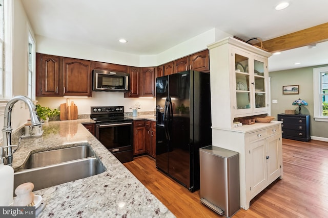 720 E Stephens Ln, Purcellville, VA 20132 - kitchen with black appliances, recessed lighting, glass insert cabinets, light wood-style floors, and light stone countertops