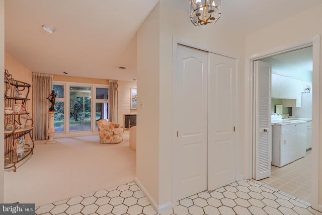 7900 Ivy Ln, Baltimore, MD 21208 - foyer entrance with separate washer and dryer, a chandelier, light carpet, a fireplace, and light flooring