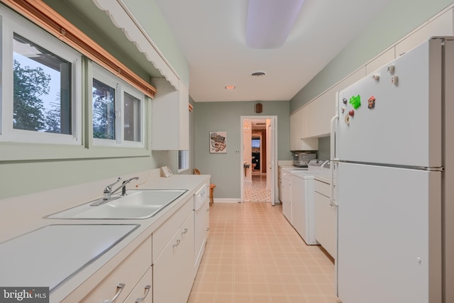 7900 Ivy Ln, Baltimore, MD 21208 - kitchen featuring freestanding refrigerator, washing machine and dryer, light floors, white cabinetry, and light countertops