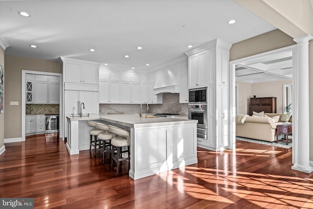 3537 Sawmill Rd, Newtown Square, PA 19073 - kitchen featuring beverage cooler, premium range hood, recessed lighting, white cabinets, and built in appliances