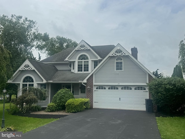 26 Sleigh Run, Reedsville, PA 17084 - victorian-style house featuring asphalt driveway, a chimney, a porch, a shingled roof, and a garage