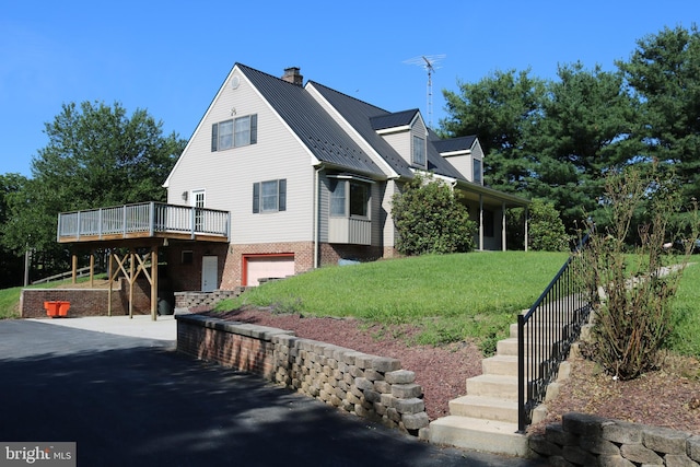 6535 Dumeny Rd, Greencastle, PA 17225 - view of front of home featuring a garage, a metal roof, a deck, a chimney, and a front lawn