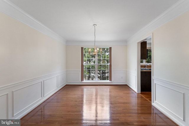 21411 Emerald Dr, Germantown, MD 20876 - unfurnished dining area featuring a chandelier, ornamental molding, a wainscoted wall, wood finished floors, and a decorative wall