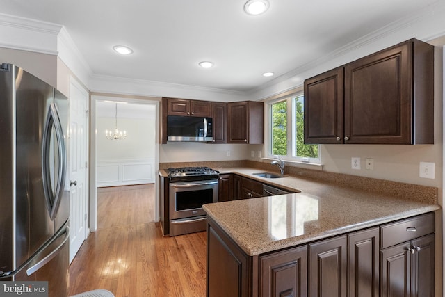 21411 Emerald Dr, Germantown, MD 20876 - kitchen featuring stainless steel appliances, a chandelier, dark brown cabinets, a peninsula, and light wood-style flooring