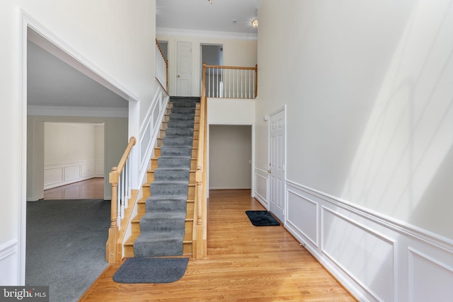 21411 Emerald Dr, Germantown, MD 20876 - stairs with a decorative wall, crown molding, and a wainscoted wall