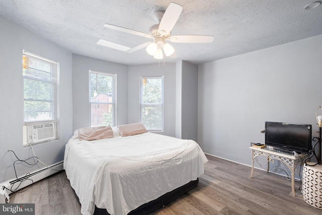 624 S Heald St, Wilmington, DE 19801 - bedroom with baseboard heating, cooling unit, a textured ceiling, wood finished floors, and ceiling fan