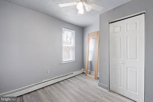 624 S Heald St, Wilmington, DE 19801 - unfurnished bedroom featuring a baseboard radiator, a textured ceiling, light wood-style floors, a closet, and ceiling fan
