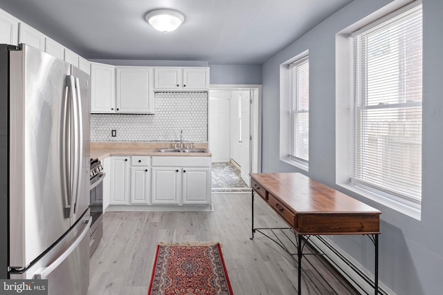 624 S Heald St, Wilmington, DE 19801 - kitchen featuring stainless steel appliances, white cabinetry, light wood finished floors, and tasteful backsplash