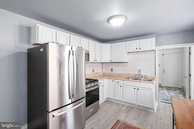 624 S Heald St, Wilmington, DE 19801 - kitchen featuring appliances with stainless steel finishes, light wood-type flooring, white cabinets, and wood counters