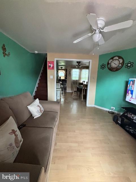 4546 N Palethorp St, Philadelphia, PA 19140 - living area featuring ceiling fan, wood finished floors, and stairway