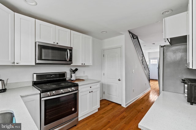 1645 S Carlisle St, Philadelphia, PA 19145 - kitchen with appliances with stainless steel finishes, light wood-style flooring, white cabinetry, and recessed lighting