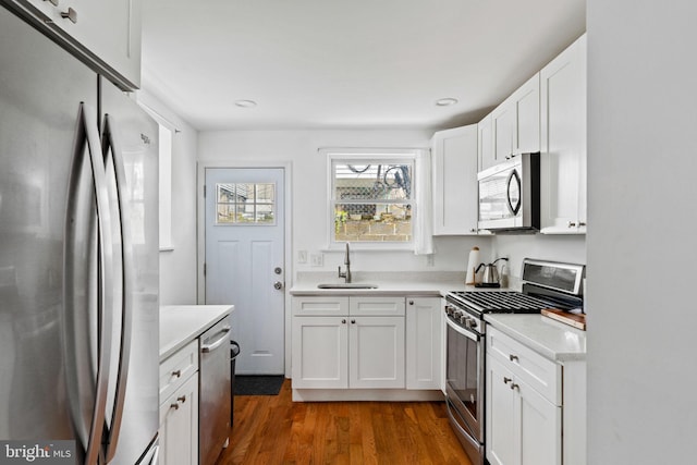 1645 S Carlisle St, Philadelphia, PA 19145 - kitchen with stainless steel appliances, light countertops, dark wood-style flooring, white cabinetry, and recessed lighting