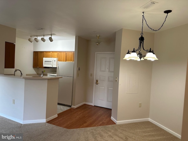 2204 Westcourt Ln Unit 313, Herndon, VA 20170 - kitchen with white appliances, brown cabinetry, a peninsula, pendant lighting, and light countertops