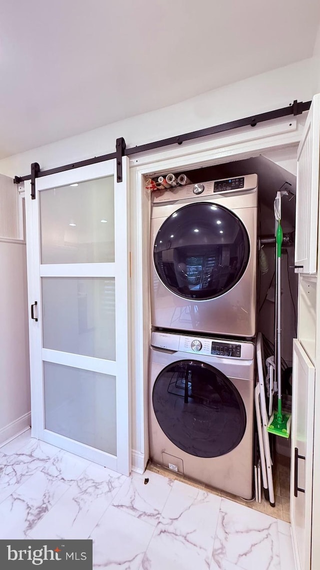 11881 Academy Rd Unit I6, Philadelphia, PA 19154 - laundry area featuring stacked washer / drying machine, a barn door, and marble look tiles