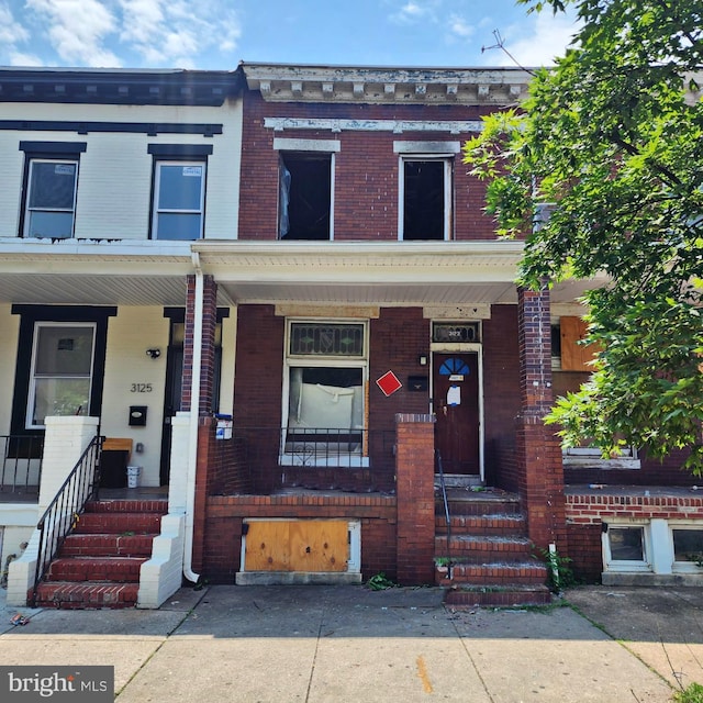 3123 Mcelderry St, Baltimore, MD 21205 - townhome / multi-family property with brick siding and covered porch