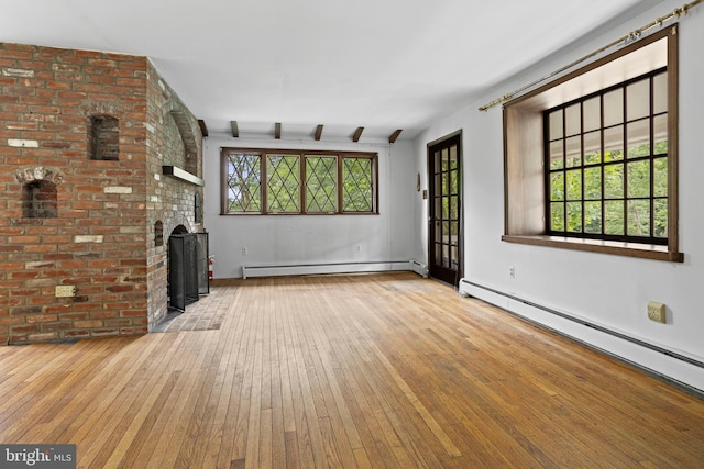 210 S Pennell Rd, Media, PA 19063 - unfurnished living room with a baseboard radiator, wood-type flooring, and a fireplace