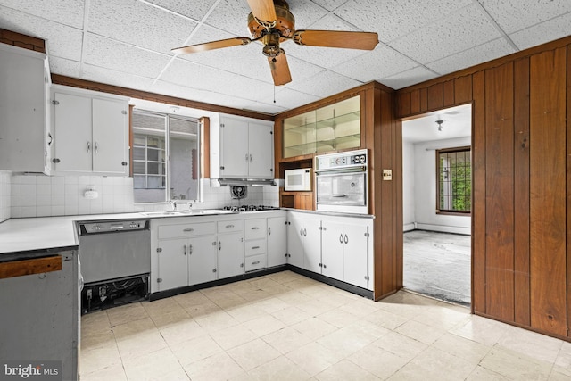210 S Pennell Rd, Media, PA 19063 - kitchen featuring appliances with stainless steel finishes, light countertops, white cabinets, decorative backsplash, and wooden walls