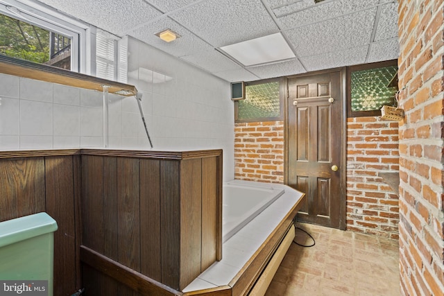 210 S Pennell Rd, Media, PA 19063 - full bath with a paneled ceiling, a garden tub, brick wall, a baseboard heating unit, and brick patterned flooring