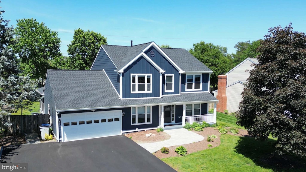 12910 Ashton Oaks Dr, Fairfax, VA 22030 - traditional-style house featuring a porch, a garage, board and batten siding, asphalt driveway, and a shingled roof