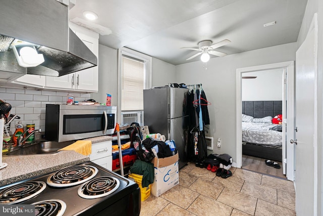 523 W Venango St, Philadelphia, PA 19140 - kitchen featuring appliances with stainless steel finishes, ventilation hood, white cabinetry, decorative backsplash, and a ceiling fan
