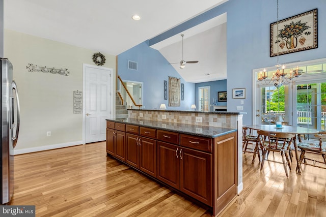5230 Canyon Creek Way, Haymarket, VA 20169 - kitchen featuring freestanding refrigerator, light wood-style flooring, dark stone counters, a chandelier, and high vaulted ceiling