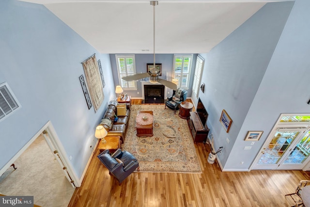 5230 Canyon Creek Way, Haymarket, VA 20169 - living room featuring wood finished floors, a fireplace with flush hearth, and a towering ceiling