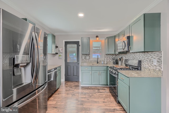 46 Avalon Ave, Dundalk, MD 21222 - kitchen with stainless steel appliances, green cabinetry, light wood-type flooring, backsplash, and crown molding