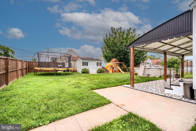 46 Avalon Ave, Dundalk, MD 21222 - fenced backyard featuring a trampoline, a storage shed, a playground, and a patio area