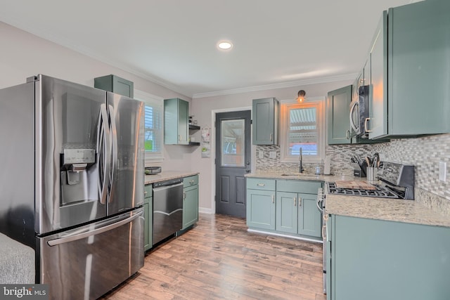 46 Avalon Ave, Dundalk, MD 21222 - kitchen featuring appliances with stainless steel finishes, ornamental molding, light wood-style floors, tasteful backsplash, and light stone countertops