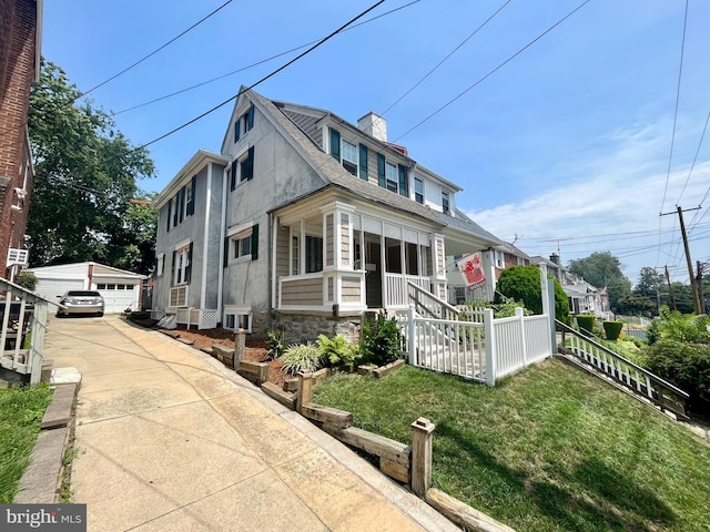 217 Bartlett Ave, Sharon Hill, PA 19079 - view of front of house featuring a porch, an outbuilding, a garage, a front lawn, and stucco siding