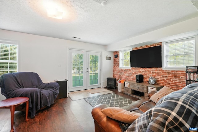 106 Alex Dr, Madison Heights, VA 24572 - living area featuring a wood stove, a textured ceiling, healthy amount of natural light, and wood finished floors