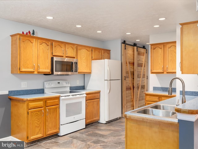 31 Westminster Dr, Front Royal, VA 22630 - kitchen with white appliances, a barn door, recessed lighting, a peninsula, and brown cabinetry