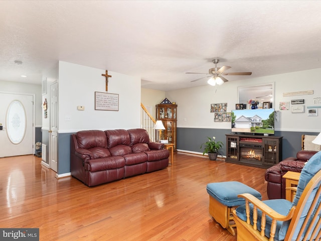 31 Westminster Dr, Front Royal, VA 22630 - living room with a ceiling fan, stairway, light wood-type flooring, a glass covered fireplace, and a textured ceiling