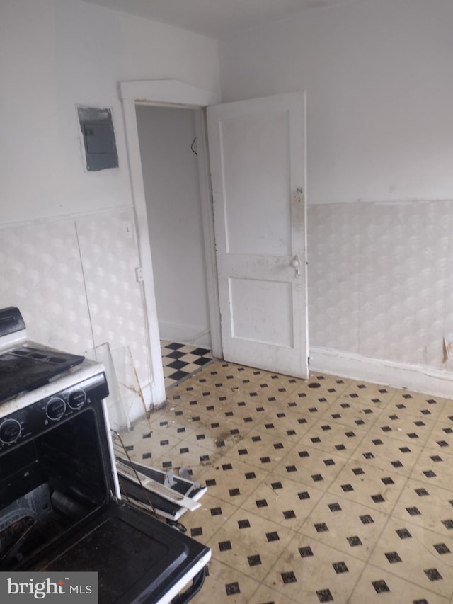 2714 E Biddle St, Baltimore, MD 21213 - kitchen featuring tile patterned floors, range with electric cooktop, and wainscoting