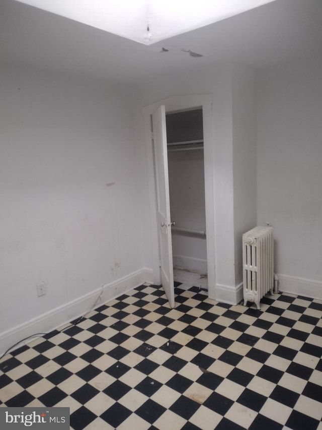 2714 E Biddle St, Baltimore, MD 21213 - unfurnished bedroom with radiator heating unit, light flooring, and a closet