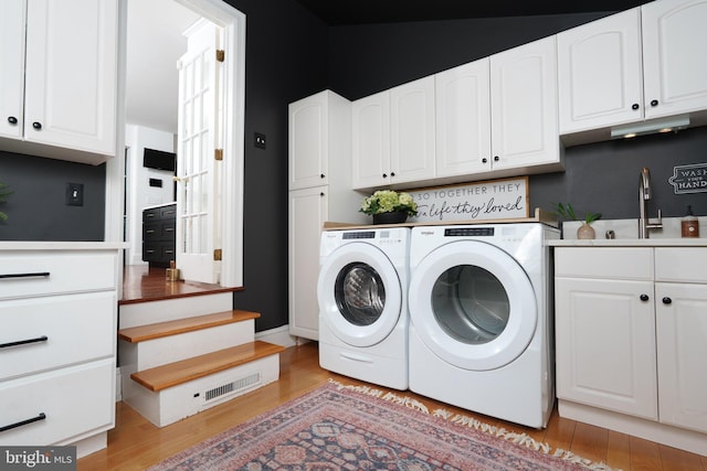 1375 Kirkland Ave, West Chester, PA 19380 - laundry room featuring independent washer and dryer, cabinet space, and light wood-type flooring