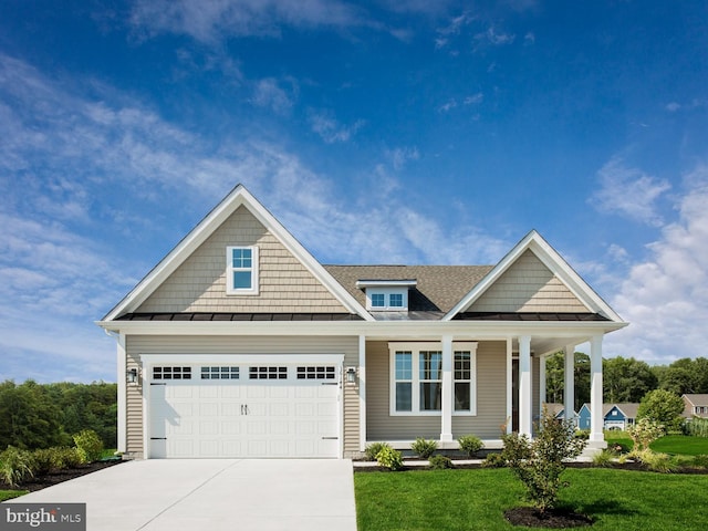 9976 Baker Ln, Ellicott City, MD 21042 - view of front of home with a standing seam roof, driveway, covered porch, a front lawn, and a metal roof