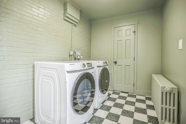 136 W 3rd Ave, Conshohocken, PA 19428 - washroom featuring radiator, washing machine and clothes dryer, brick wall, and dark floors
