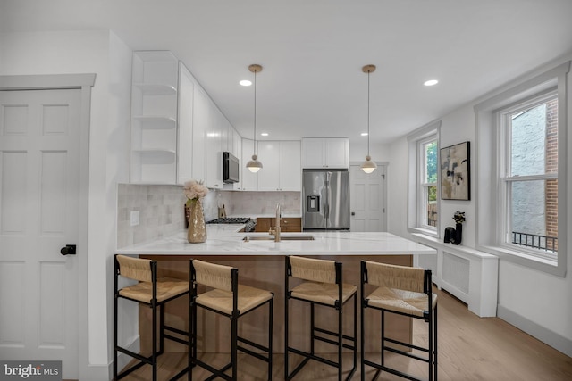 136 W 3rd Ave, Conshohocken, PA 19428 - kitchen featuring stainless steel appliances, open shelves, a peninsula, decorative backsplash, and light wood-style flooring