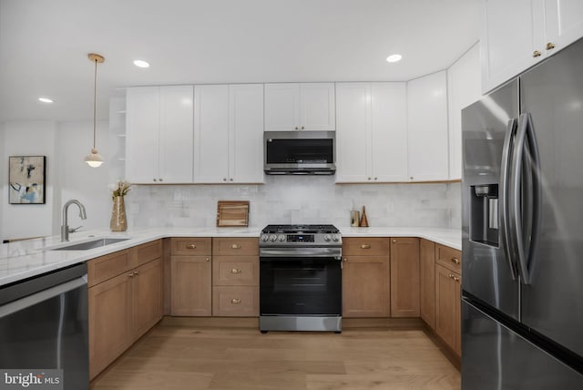 136 W 3rd Ave, Conshohocken, PA 19428 - kitchen with appliances with stainless steel finishes, light wood finished floors, backsplash, decorative light fixtures, and recessed lighting